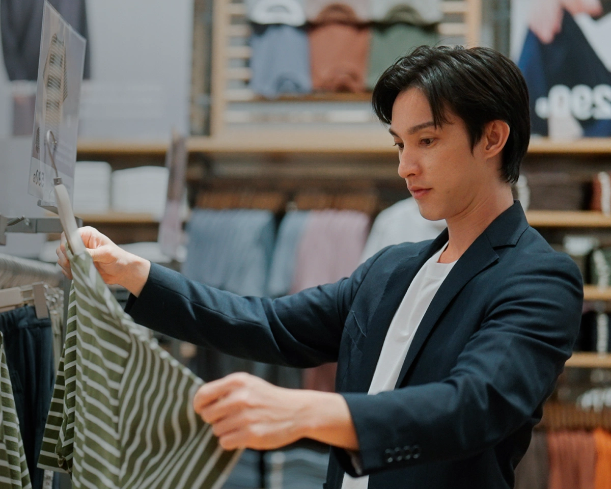 Person checking a price tag while thinking about spending habits.