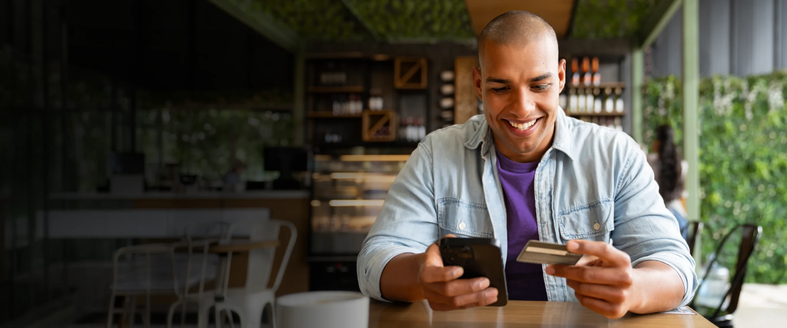 Person using a phone and payment card while learning how credit works.