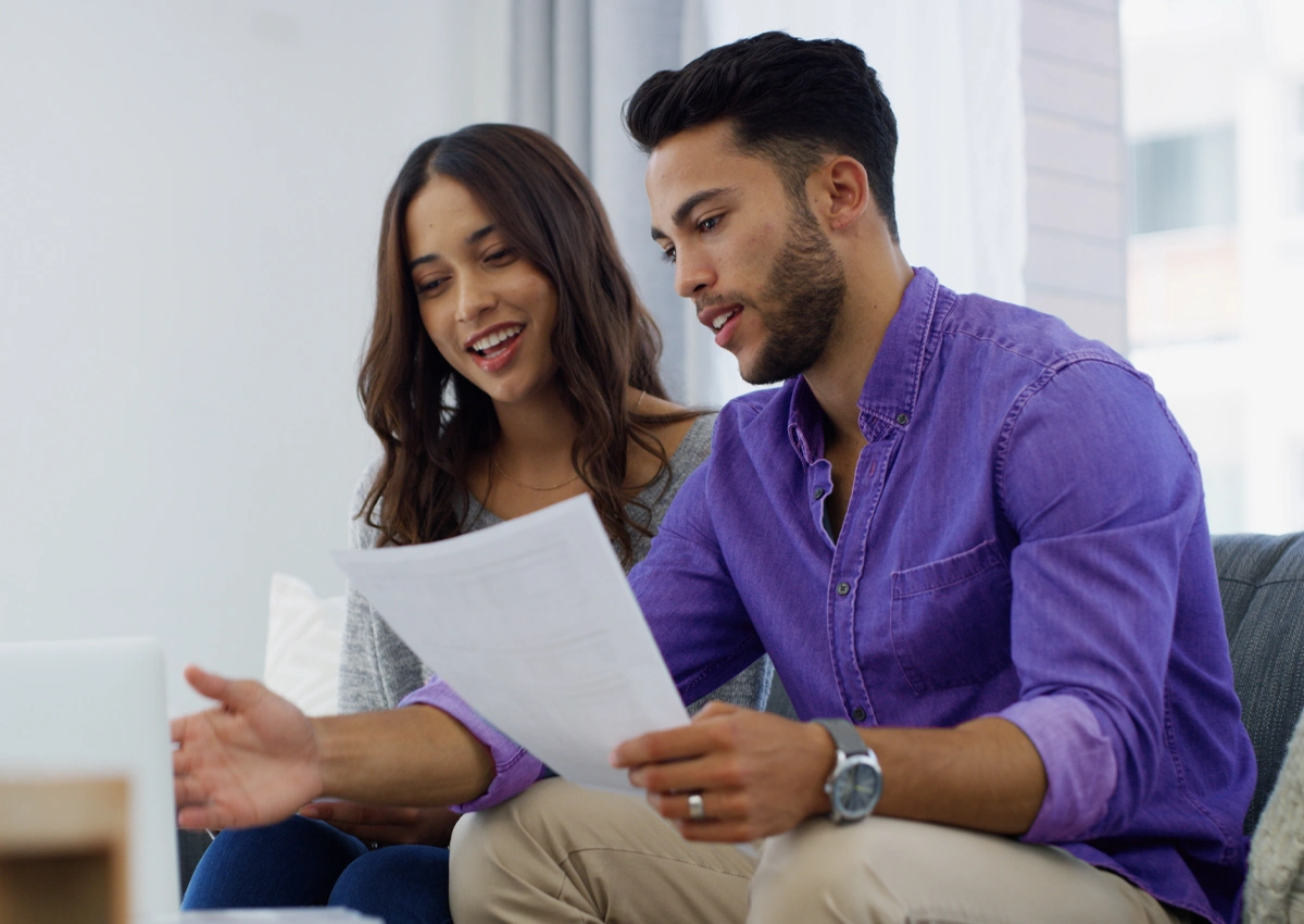 Two people reviewing paperwork while planning how to manage debt.