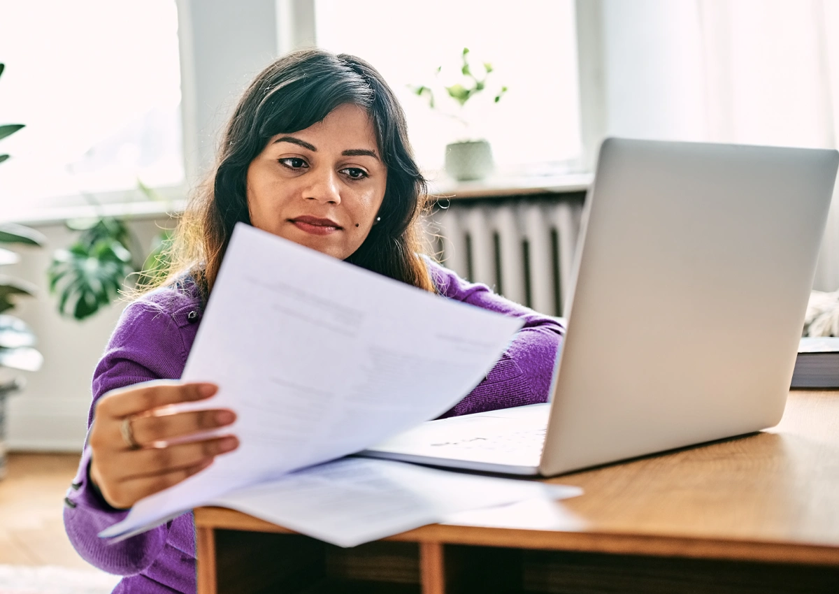 Person reviewing paperwork to prepare for unexpected expenses.