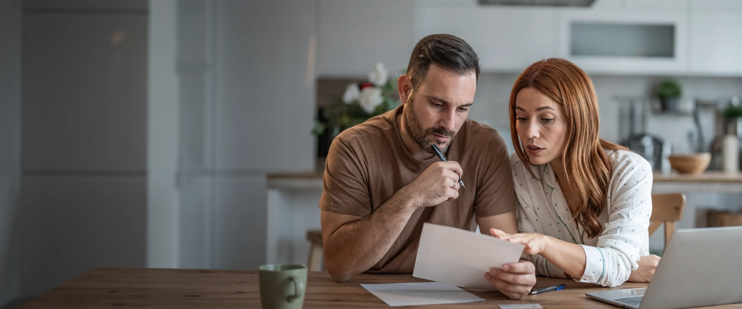 Two people reviewing paperwork while preparing for a financial emergency.