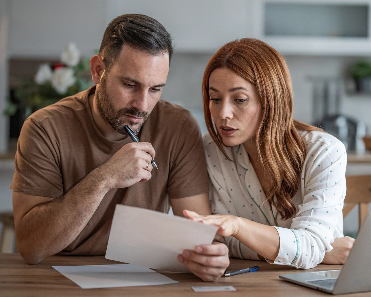 Two people reviewing paperwork while preparing for a financial emergency.