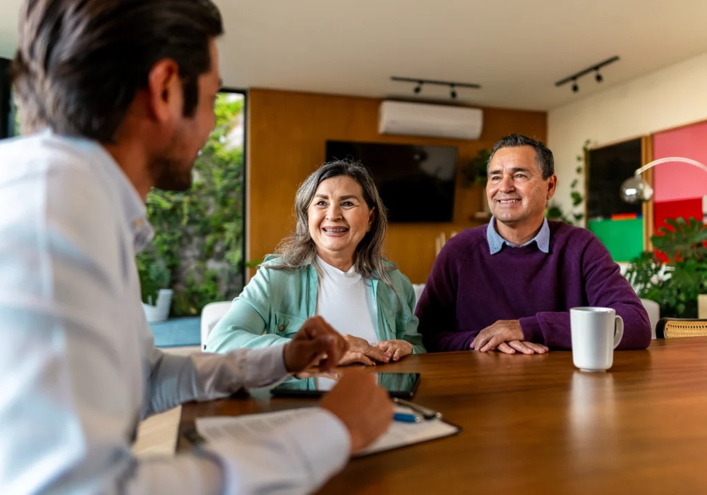 A couple sits at a table in an office with a lender and discusses their lending options.