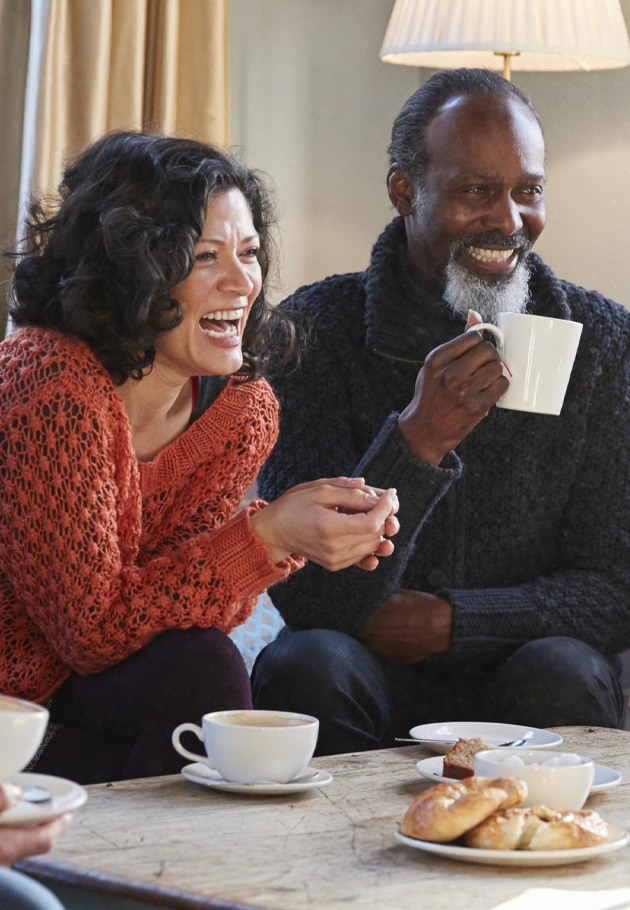 Two people smiling while talking with friends.