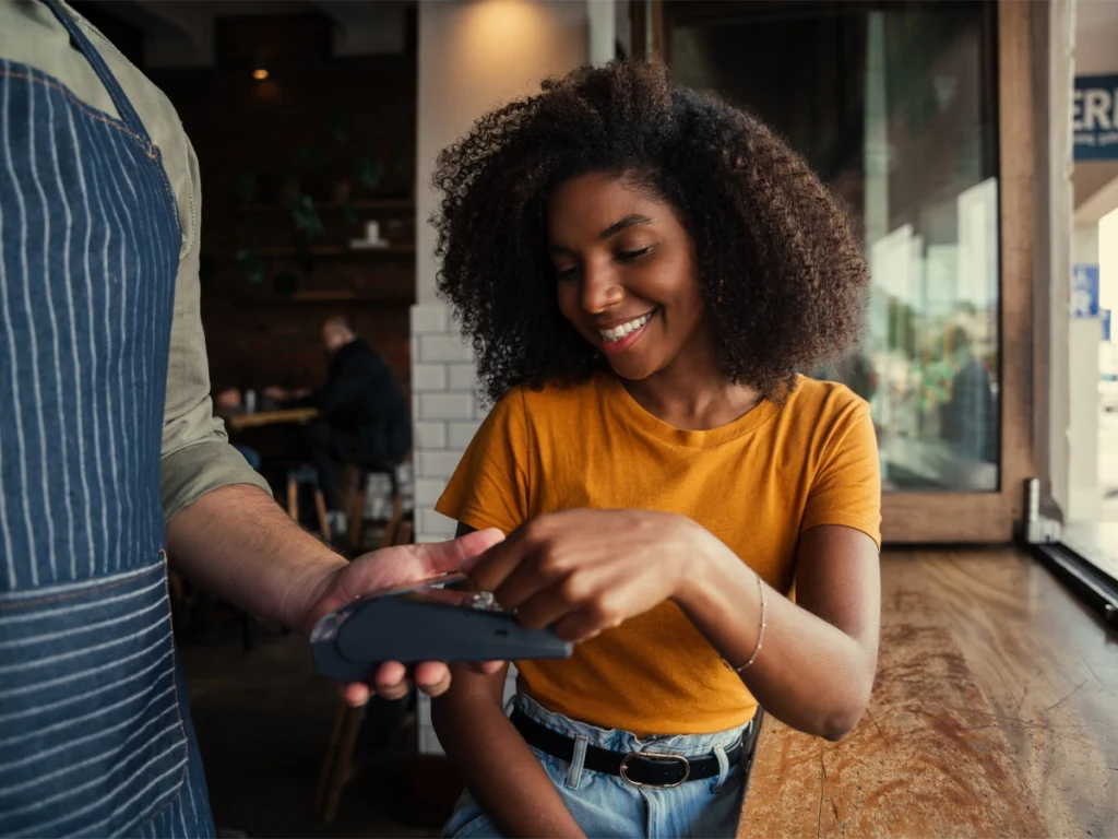 Person making an everyday purchase while managing financial goals.