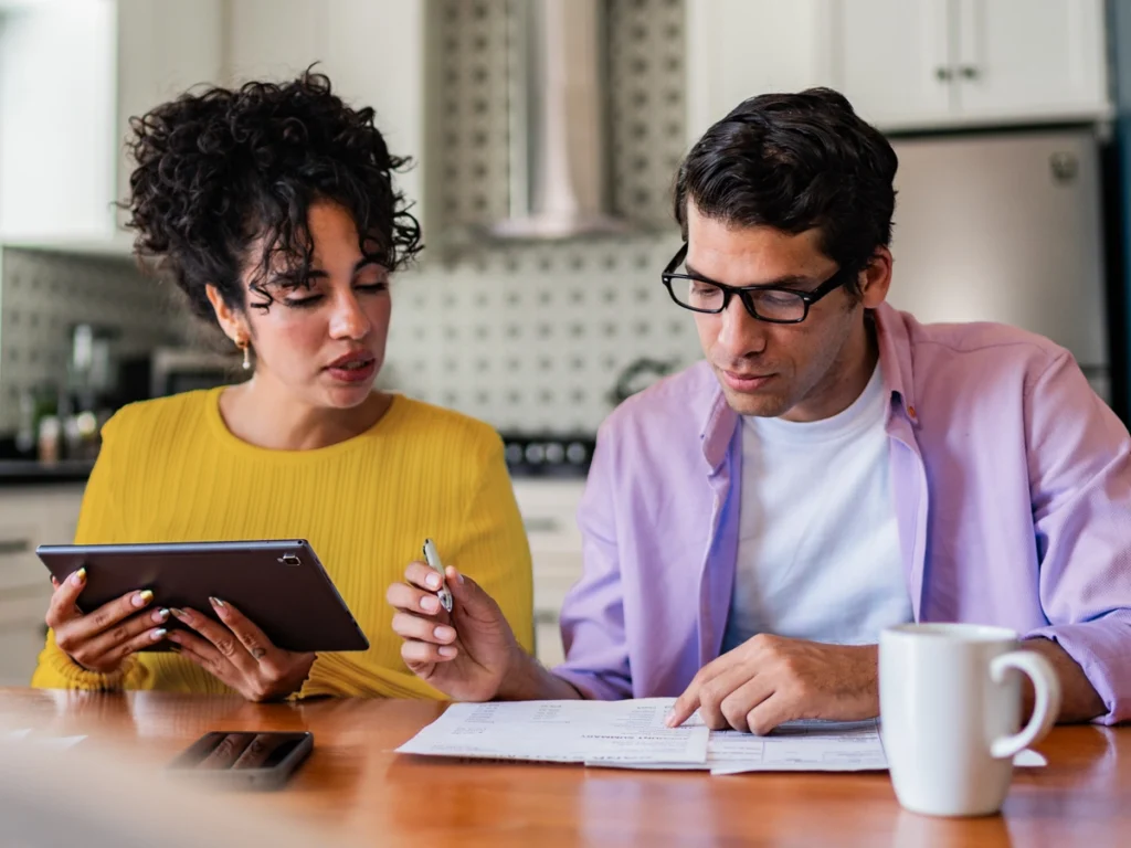 Two people using a tablet to start personalized financial coaching.