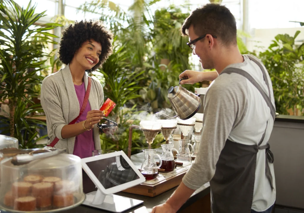 A woman in charge of her financial habits confidently
makes a purchase at a local cafe.